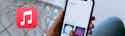 Apple Music Debuts Lyrics Translation and Karaoke Features header Hand holding smartphone displaying music library interface with album artwork, red music note app icon visible in corner.