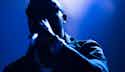 Music Promotion A silhouetted figure in a dark, blue-tinted scene, with a hand raised in the foreground.