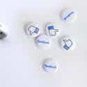 white earbuds and Facebook buttons on a white surface