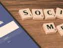 smart phone with Facebook login and Scrabble letters spelling social media