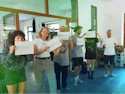 Our Mission min Un groupe de jeunes tenant des pancartes avec des messages dans un espace intérieur.