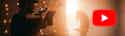 You Tube for Musicians 7 Tips to Boost Your Online Visibility header Kameramann filmt Person in warmem Licht, YouTube-Logo rechts, orange-gelbe Beleuchtung dominiert die Szene.