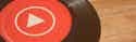 Disco de vinilo negro con logo de YouTube Music rojo